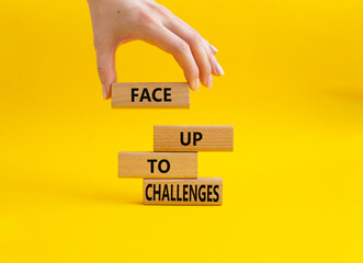 Face up to challenges symbol. Wooden blocks with words Face up to challenges. Beautiful yellow background. Businessman hand. Business and Face up to challenges concept. Copy space.