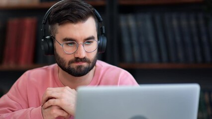 Closeup male headphones talking online video call use laptop consulting remotely working at library