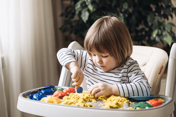 Cute little boy playing with kinetic sand. Development of fine motor skills. Early sensory education. Activities Montessori. Sensory plays at home.