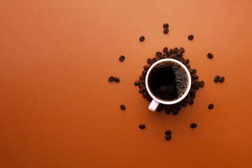 White coffee cup on brown background with coffee beans forming clock face. Coffee as symbol of morning energy and cheerfulness
