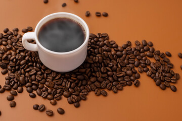 Coffee cup with smoke and freshly roasted coffee beans with copy space