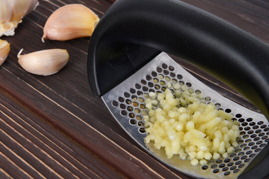 Garlic press and cloves of garlic