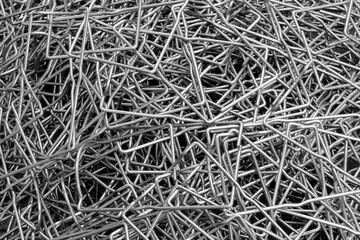 Metal texture background made of many bent steel wires, Close-up, industrial metalworking concept