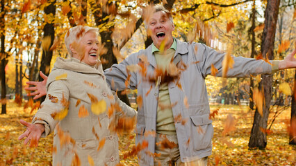 Happy married elderly caucasian couple partners in civil park mature woman senior man scatter...