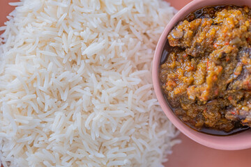Bowl of rice served with Ofada and Pepper tomato stew