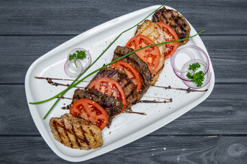 meat steak tomato on gray wooden background