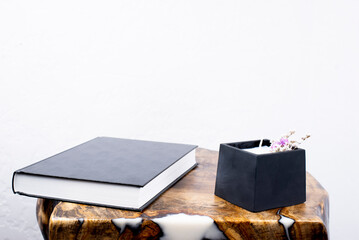 Decorative candle. Books on the table. Texture. Table made of wood and epoxy resin. Furniture.