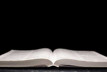 Open Bible. On a black background. Holy book.