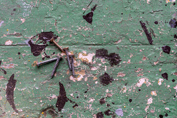 metal screws on an old painted exfoliating wooden table