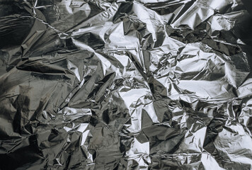Background, texture of silver shiny foil, colored crumpled paper. Photo, top view, copy space.