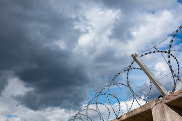 Barbed wire fence with the sky in the background.
