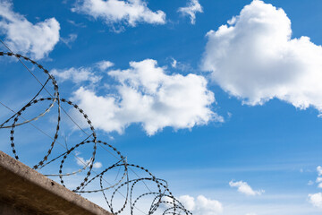 Barbed wire fence with the sky in the background.