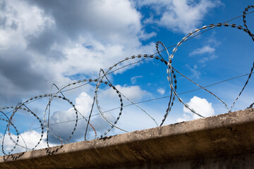Barbed wire fence with the sky in the background.