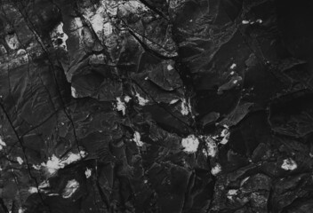 Dark marble. Black texture. Stone background. Rock texture. Rock surface with cracks. Rock pile. Paint spots wall. Grunge Rough structure. Abstract texture.