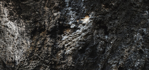 Fototapeta na wymiar Rock surface with cracks. Black texture. Stone background. Dark marble. Rock texture. Rock pile. Paint spots wall. Grunge Rough structure. Abstract texture.