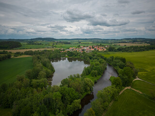 Naklejka premium Pond and river infront of village