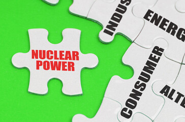 On a green surface are white puzzles with text, on a separate puzzle there is an inscription - Nuclear power