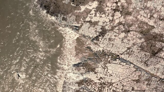 Aerial view of rocky Coast with waves from a top down view, Monk nash south wales.