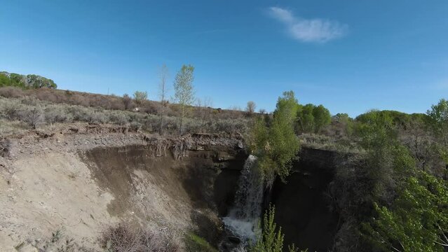 FPV Aerial Drone Flying over Shoshone River with a Water Fall followed by water ponds and white bee hive boxes in Powell Wyoming on Summer Sunny Day with Cinematic Movement