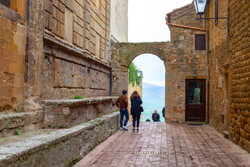 People walking along ancient stone street of Pienza Val d'Orcia Tuscany
