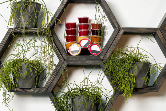 Liquid tea infusion in plastic containers stands on a stand. The concept of healthy eating. Red orange green liquid tea infusion