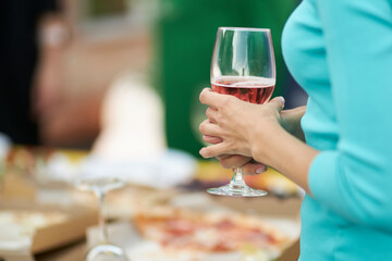 girl holding a glass of white wine in her hands, at a party, close-up