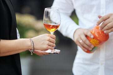 girl holding a glass of white wine in her hands, at a party, close-up