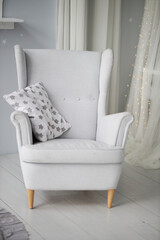 Gray armchair with a pillow in the interior, close-up