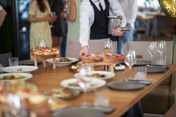 the waiter serves a festive table in a cafe, selective focus