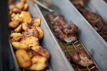 Grilled vegetables and chicken on distribution in iron trays , containers