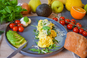 French omelette dish. Delicous homemade french omlette filled with cheese. Plating with fresh vegetables like avocado, cherry tomatoes, but also basil and mozzarella.