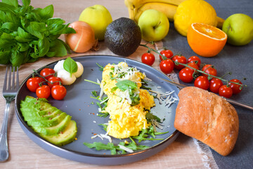 French omelette dish. Delicous homemade french omlette filled with cheese. Plating with fresh vegetables like avocado, cherry tomatoes, but also basil and mozzarella.
