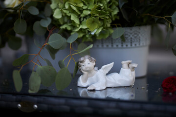 ceramic figurine of an angel, on a table in the garden, close-up