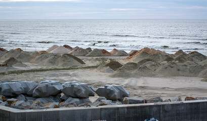 Zwały piasku i kamieni na plaży na budowie przekopu	
