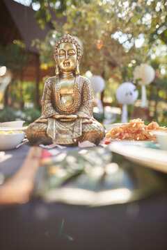 Bronze Buddha figurine in nature, at a picnic, close-up of the Buddha figurine