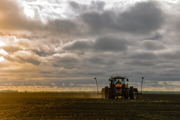 Fototapeta premium A tractor with a seed drill is engaged in planting corn. Agricultural industry development concept.