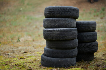 Fototapeta na wymiar Tires are stacked on a background of green grass. car tires
