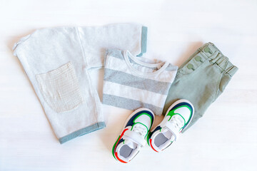 Jumper,t shirt and jeans pants with sneakers. Set of baby children's clothes and accessories for spring, autumn or summer on white background. Fashion kids outfit. Flat lay, top view,overhead,mock up
