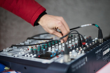 Hand adjusting audio mixer. sound engineer hands working on sound mixer in live concert. DJ controlled the sound system by mixer equalizer in concert.