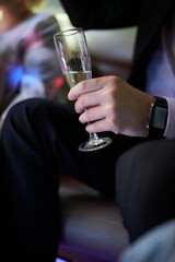 a man holds a glass of champagne in his hands. a glass of champagne in male hands, close-up