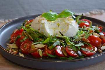 Burrata Salad with Cherry Tomatoes, Rucola, Basil, Olive Oil and Balsamic Creme. Burrata fresh cheeses tastes amazing and can be served alongside tomatoes, grilled bread, or vegetables.