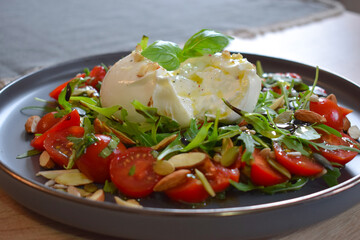 Burrata Salad with Cherry Tomatoes, Rucola, Basil, Olive Oil and Balsamic Creme. Burrata fresh cheeses tastes amazing and can be served alongside tomatoes, grilled bread, or vegetables.