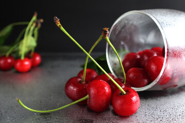 cherry red ripe berry fell out of the glass on a black background with the est for the text. vitamins seasonal berry hemoglobin
