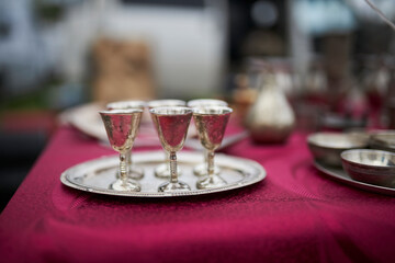 silver glasses on a silver dish on the table, red tablecloth