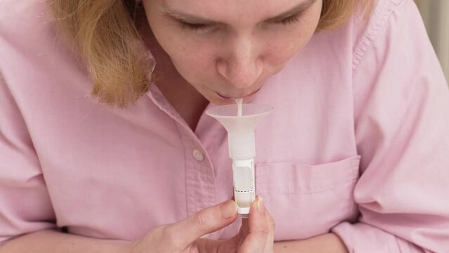 a woman collects saliva in a container for a dna test. 