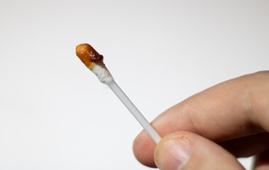cotton bud with earwax in hand