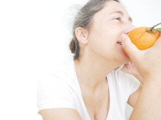 Forty nine year old woman in a white T-Shirt against a white background with an orange