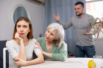 Elderly mother comforts her adult daughter after her quarrel with her husband