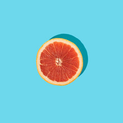 Grapefruit slice on blue background. Minimal summer fruits concept. Pop art.