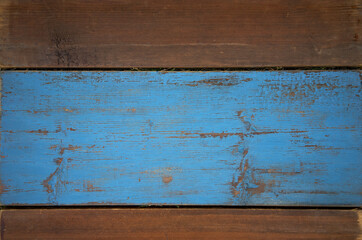 Photo of the texture of a wooden fence. A fence made of wood with horizontal stripes. The wooden background is blue. The wall is made of wood with blue paint. Blue wooden background for text.